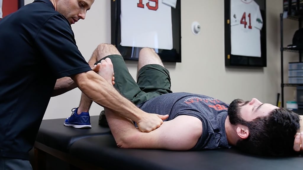 physical therapy on a man who is laying